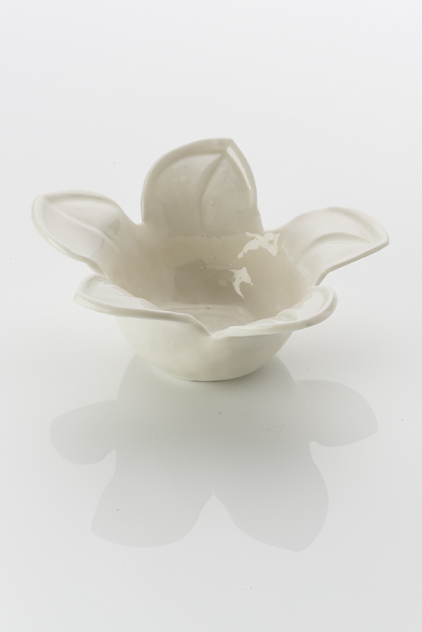 Hand made ceramic bowl made from a white clay body, washed over with a shiny glaze. The rim of the bowl blooms open with five leaf-like petals, each indented in the middle.